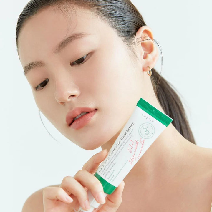 koreansk pige stor med produkt - Axis-Y Dark Spot Correcting Glow Serum – serum med 5% niacinamid, squalane og papajaekstrakt, reducerer pigmentpletter, akne-ar og giver ensartet glød