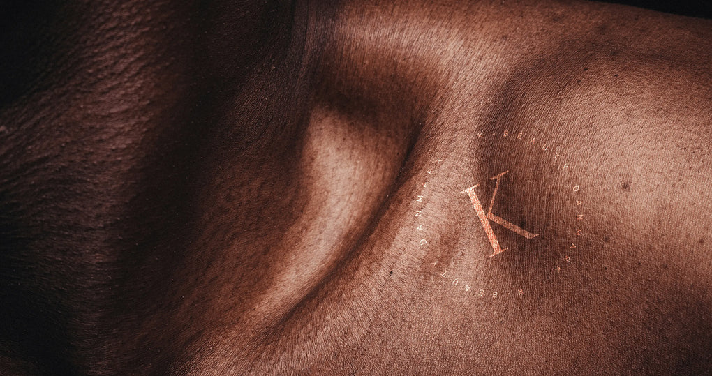 Baggrundsbillede til tilmeld nyhedsmail. Forstiller en flot brun hud tæt på kravebenet på en kvinde og med K-Beauty Danmark logo